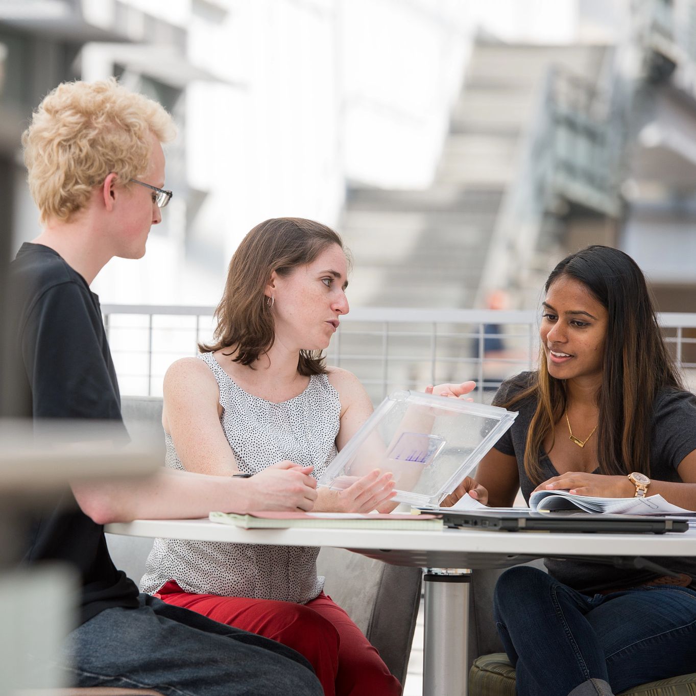 Students sit with faculty member at a desk in the CBIS building